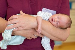 Frühgeborenes in den Armen einer Mitarbeiterin der Klinik für Neonatologie