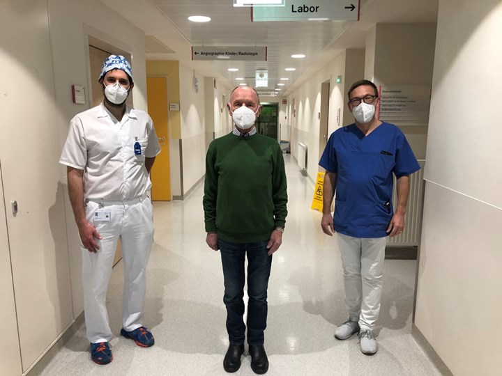Patient mit zwei Ärzten am Krankenhausgang